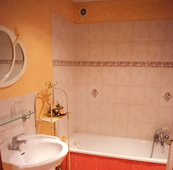 Une salle de bains avec une grande baignoire, et des toilettes séparées équipent la chambre.
