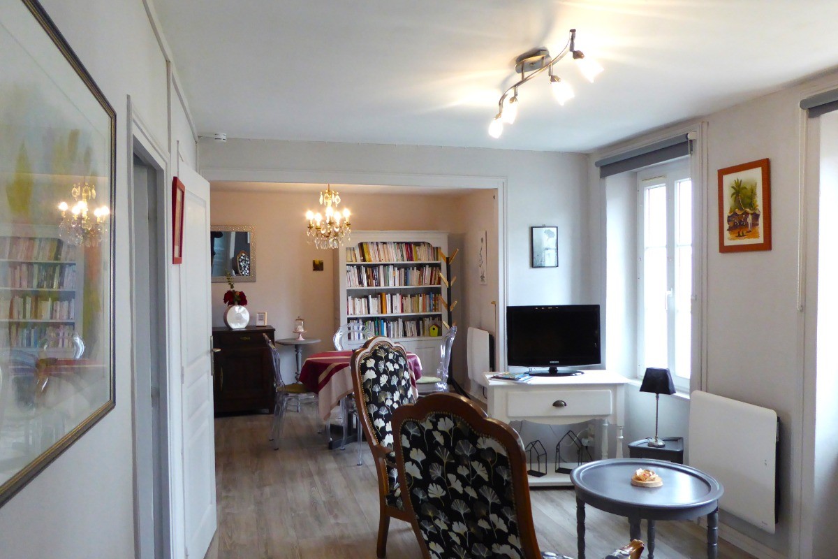Coin salon avec TV (canapé-lit  confortable, pour 1 personne). En enfilade le coin séjour. A gauche la cuisine indépendante.