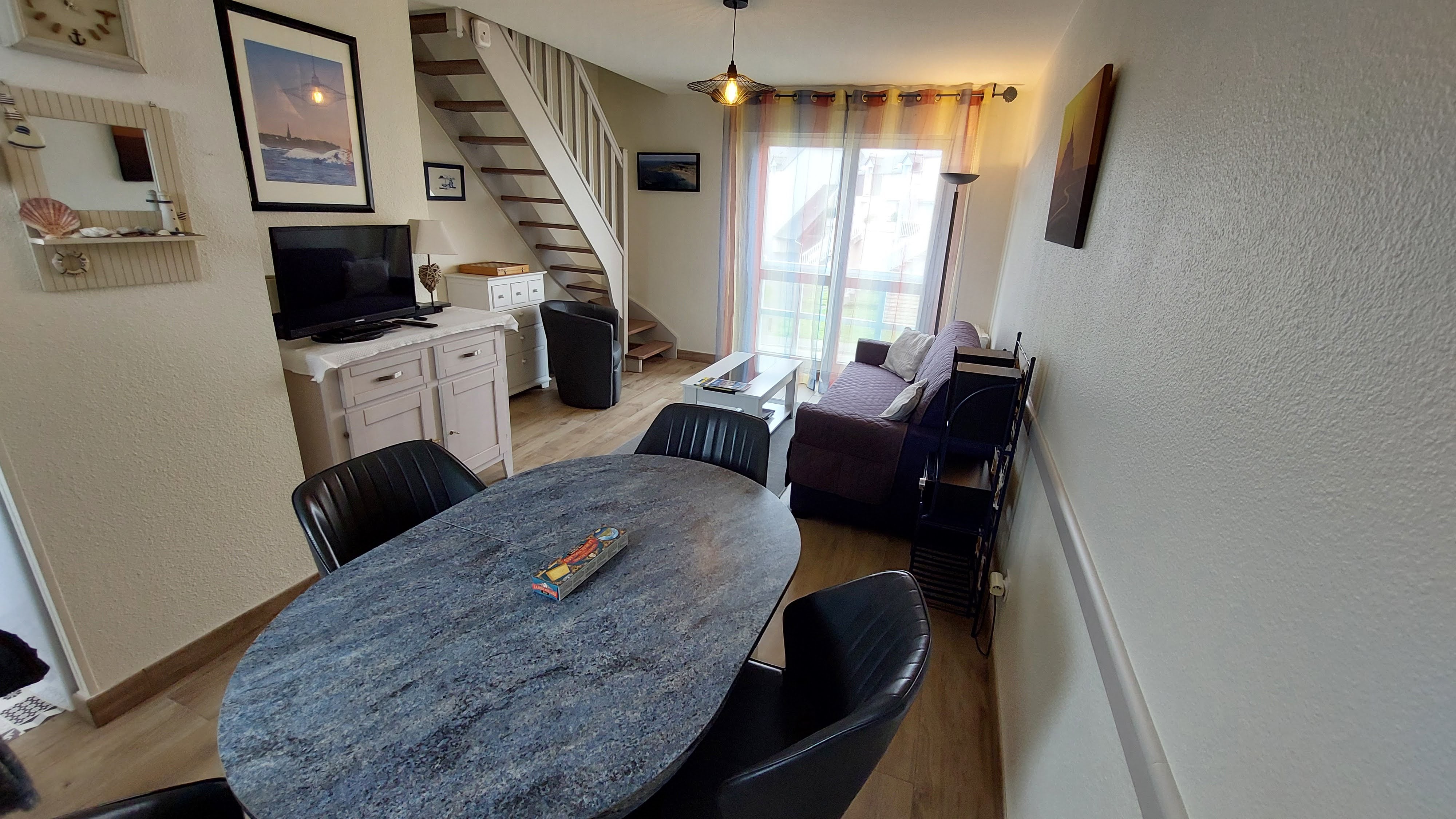 Le séjour-salon avec l'escalier donnant accès aux chambres et salle d'eau