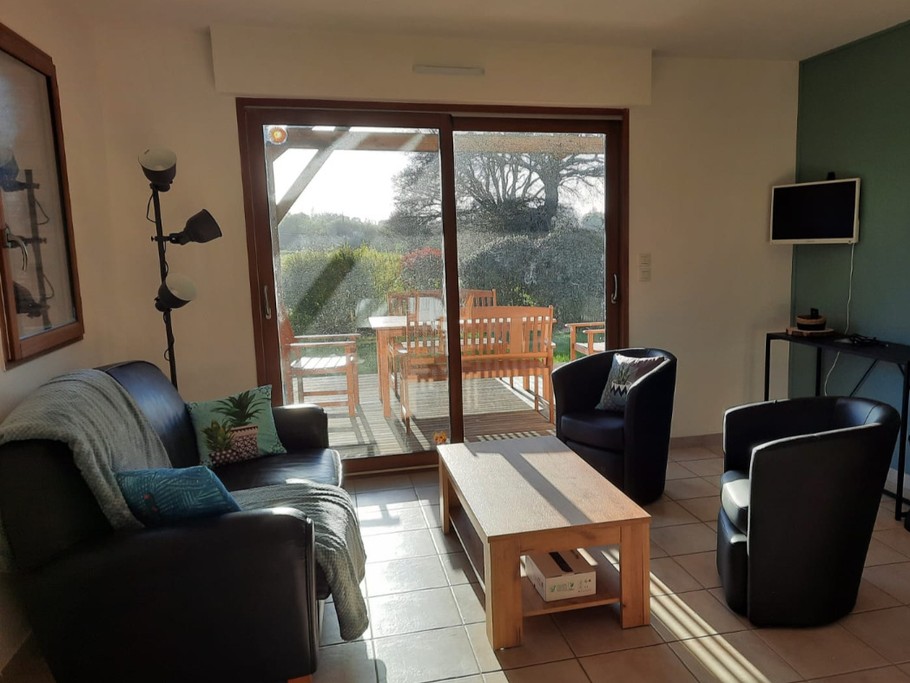 Salon avec baie vitrée donnant sur la terrasse et le jardin