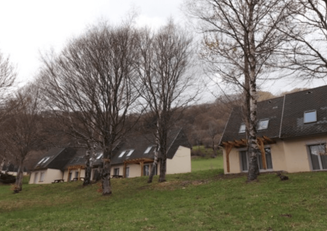 Façade du gîte avec vue sur les paysages du Parc des Volcans d'Auvergne.