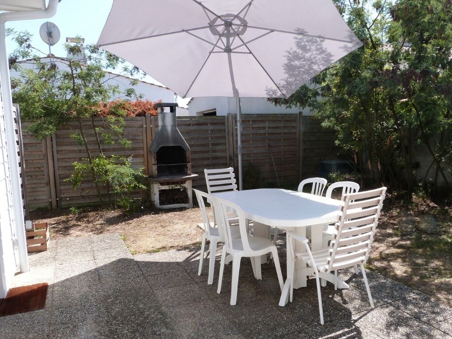 Terrasse avec salon de jardin, parasol et barbecue