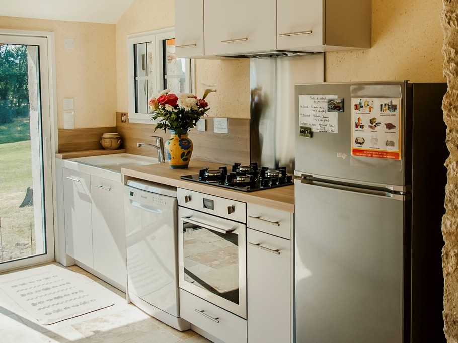 La cuisine aménagée donnant sur la terrasse du gite "Les Sens Ciel" pour 6 personnes, avec lave-vaisselle, réfrigérateur et four, en Indre et Loir