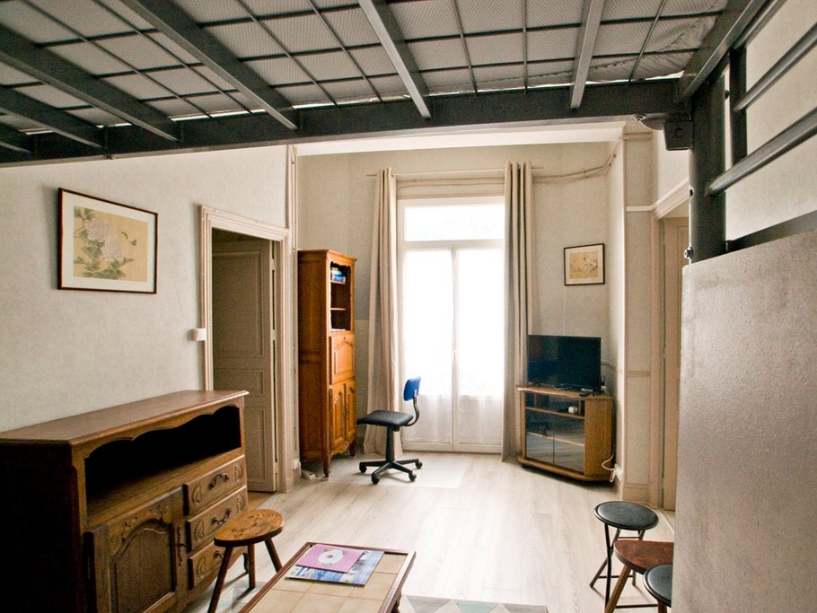 salon avec mezzanine, lit de 140 x 190, et canapé BZ également en 140 x 190, penderie et rangements sous l'escalier de la mezzanine