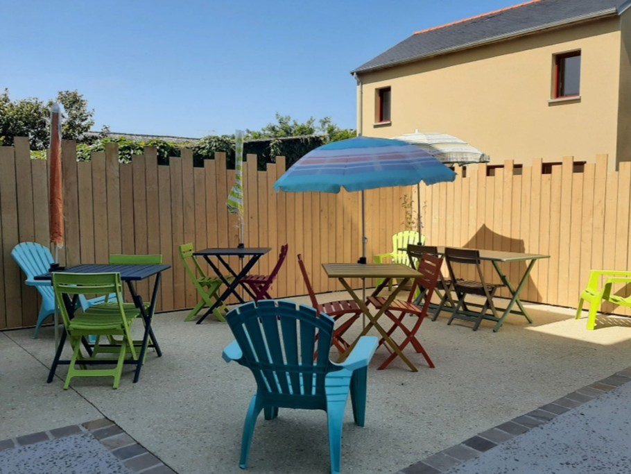 Terrasse ensoleillée avec tables de jardin. Barbecue à disposition.