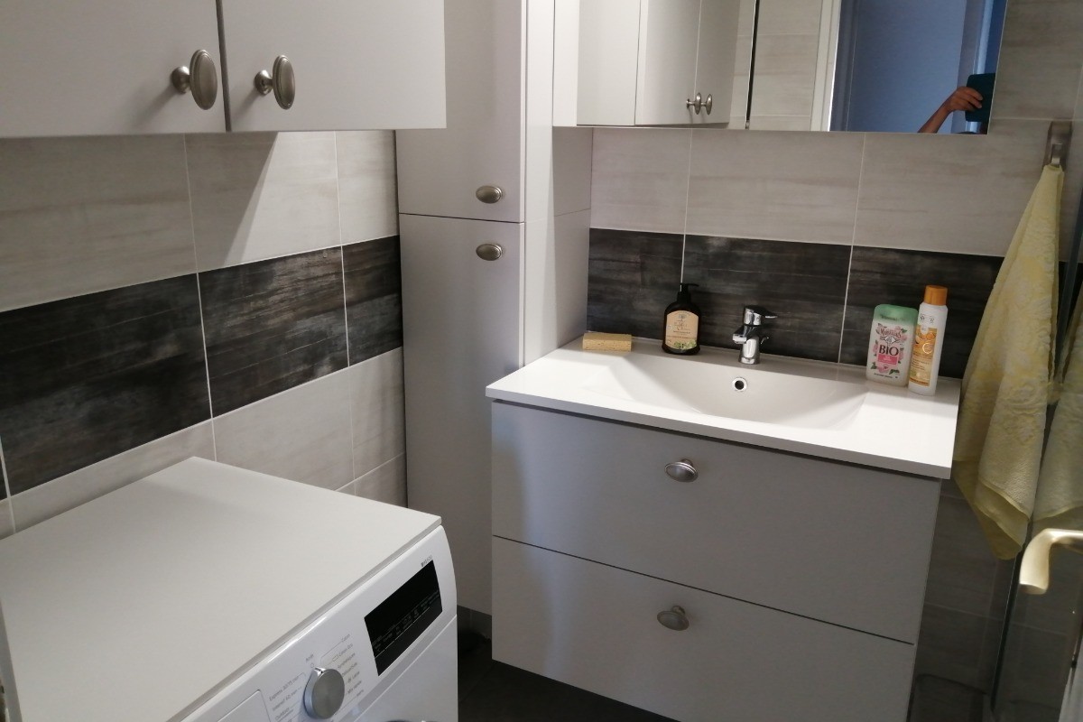 salle d'eau avec machine à laver et rangements