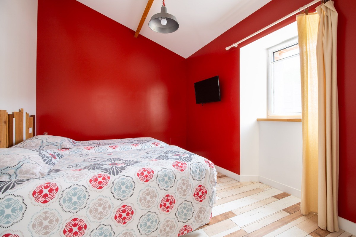 Chambre avec deux lits simples, grand placard et TV.