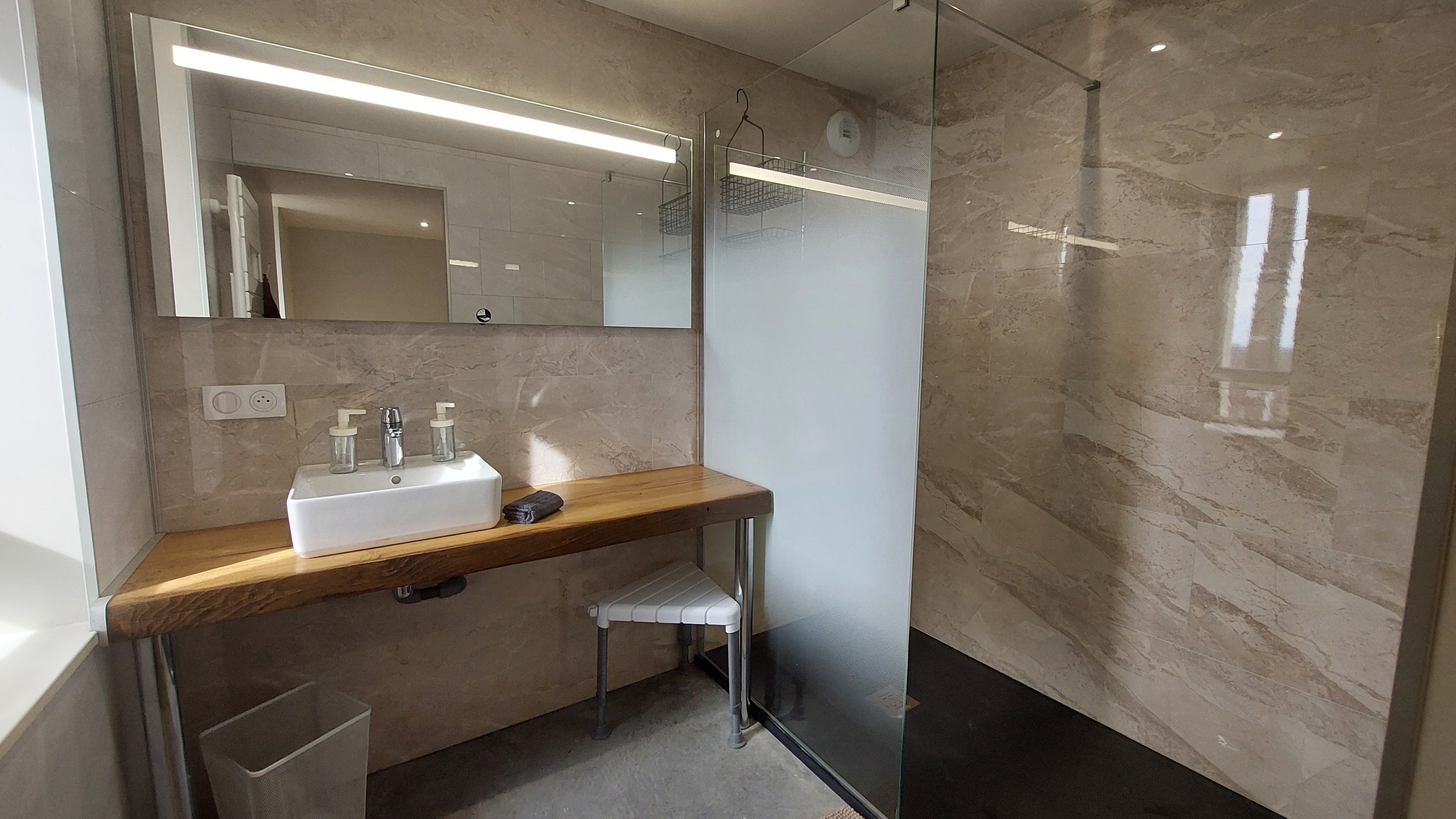 Salle de bain PMR avec douche adaptée et équipements accessibles