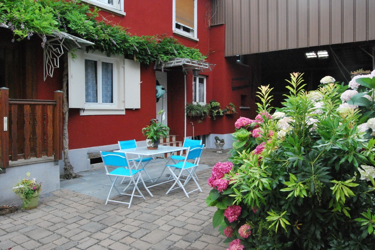 Un extérieur avec un salon de jardin.