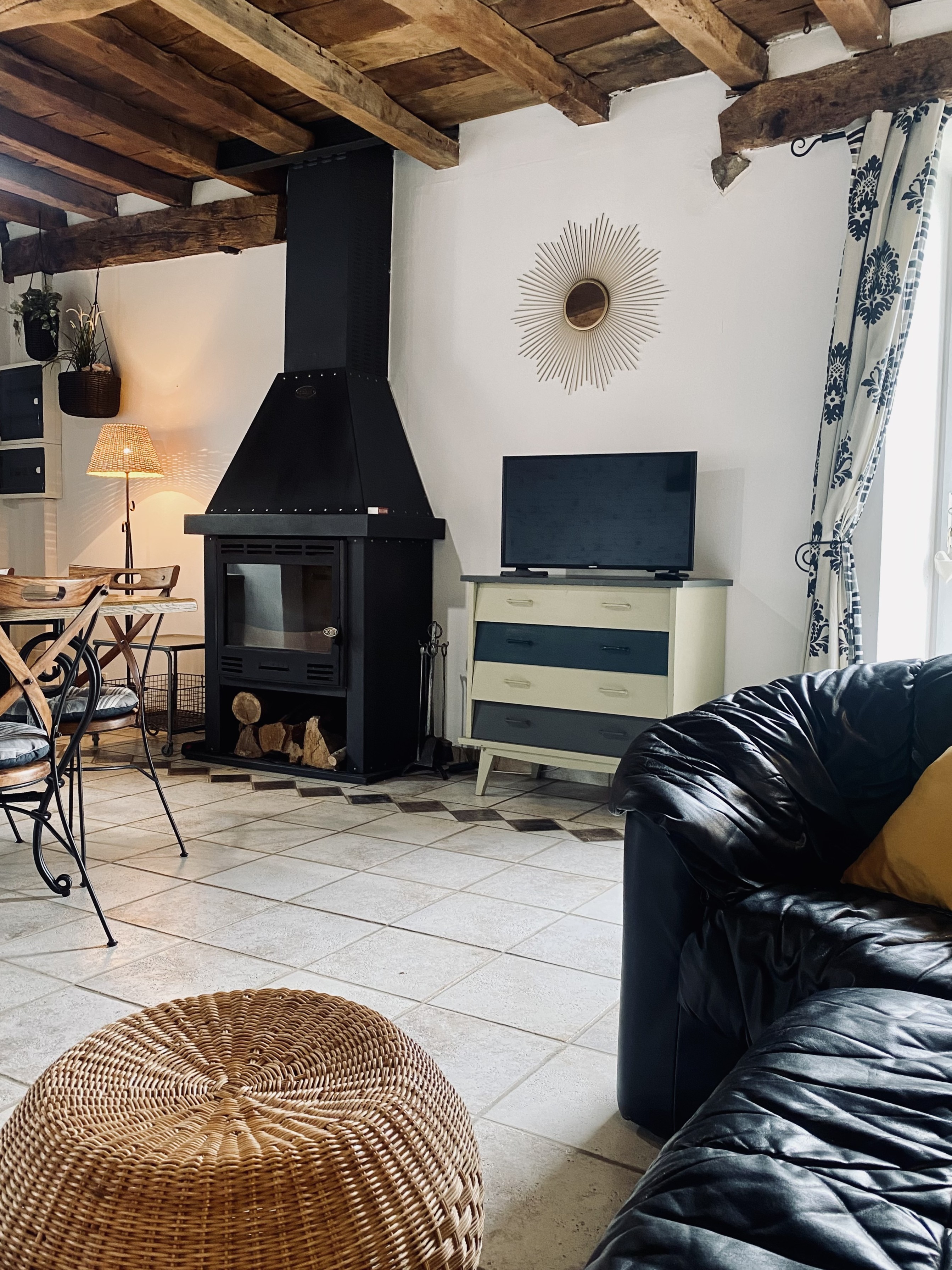 Grande pièce de vie au rez-de-chaussée avec espace cuisine toute aménagée et son mini bar, espace séjour, espace (vrai) bureau, et espace salon avec canapé en cuir, poêle à bois et TV.