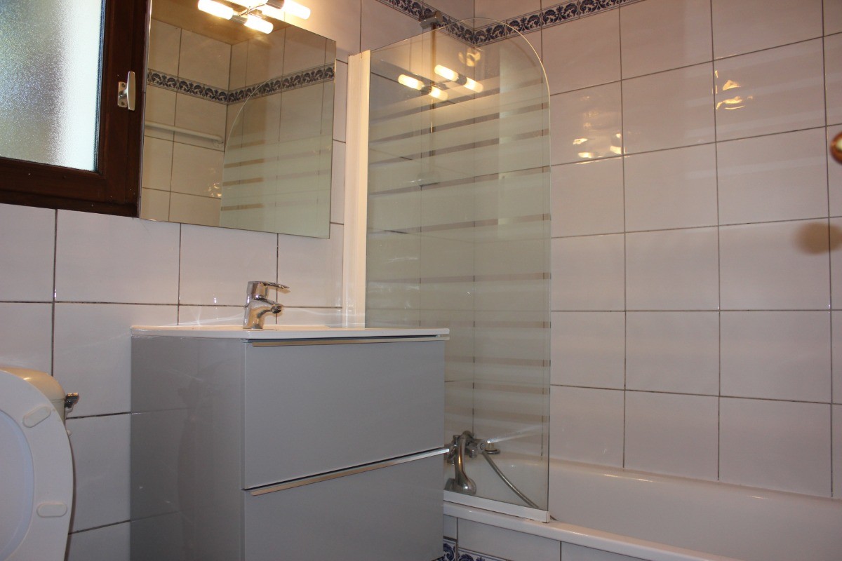 Salle de bain avec baignoire et WC.