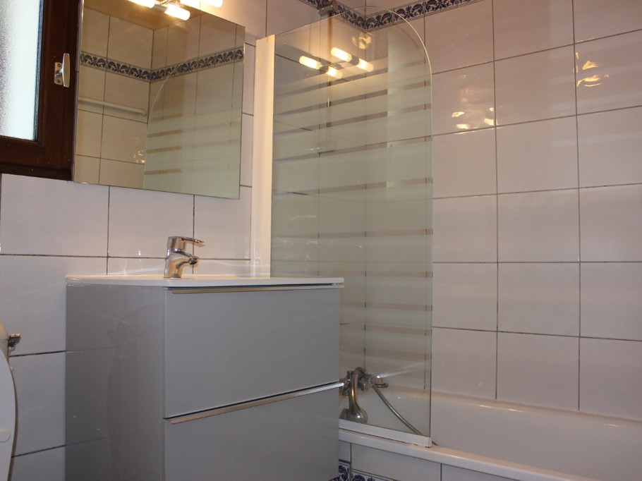 Salle de bain avec baignoire et WC.