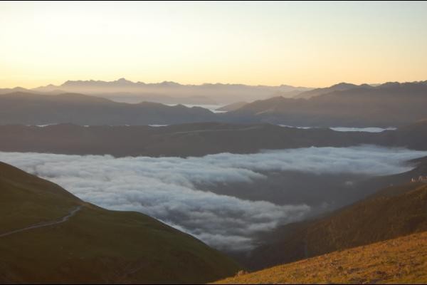 Le soleil attaque les cimes au-dessus de la mer de nuages qui recouvre la vallée