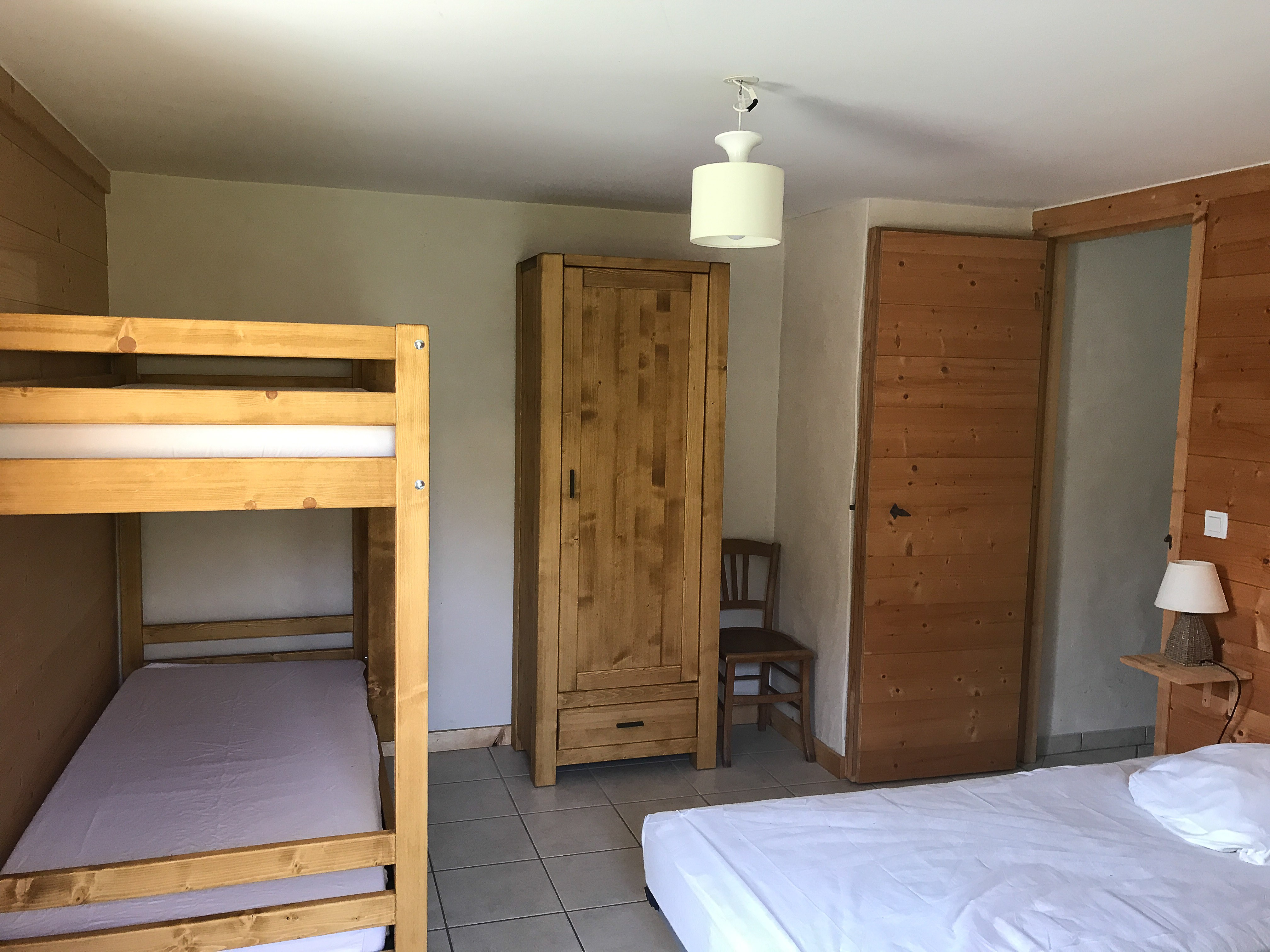 Chambre sous la terrasse avec lits superposés et 2 lits jumeaux, accès extérieur