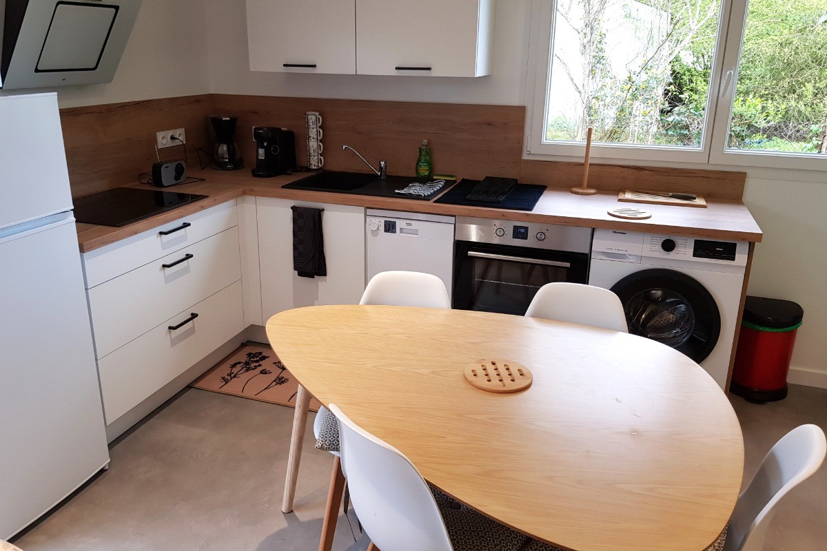 Coin cuisine toute équipée et sa table à manger (lave-vaisselle, four, micro-ondes, combiné-congélation, petits électroménagers, lave-linge, etc.)