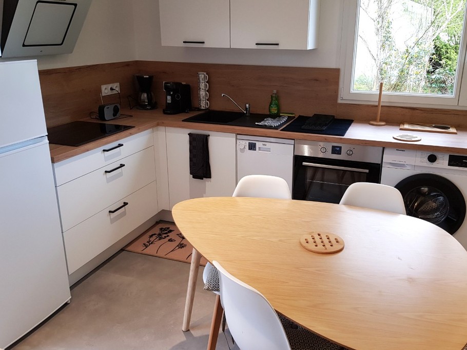Coin cuisine toute équipée et sa table à manger (lave-vaisselle, four, micro-ondes, combiné-congélation, petits électroménagers, lave-linge, etc.)