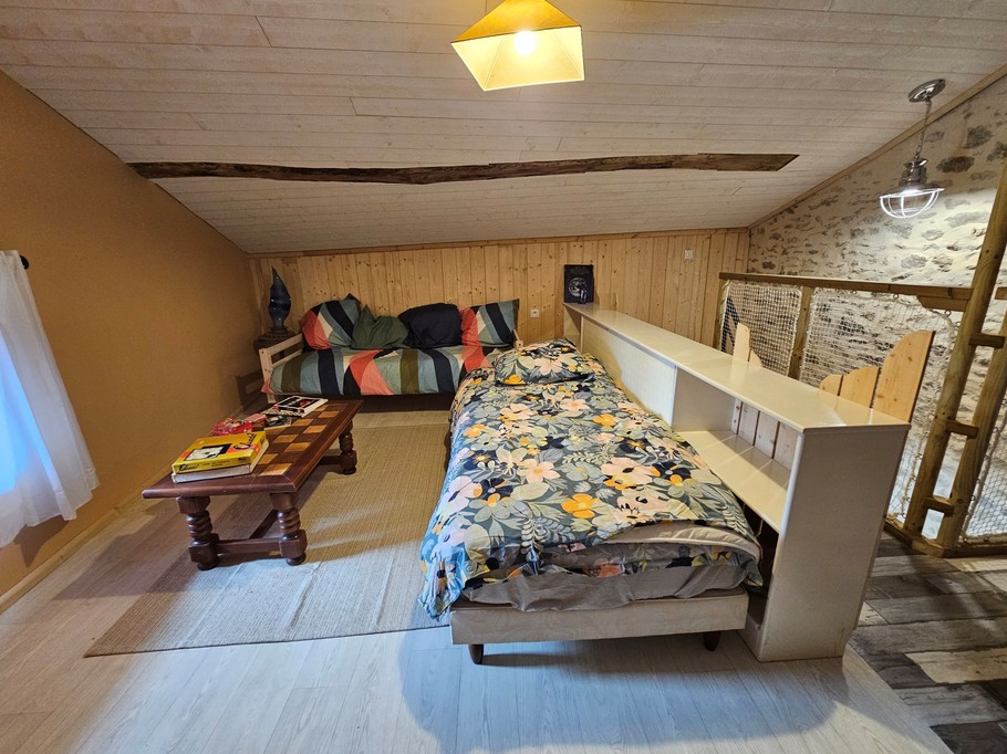 En haut de l'escalier, grande chambre avec 3 lits dont un 140, et une bibliothèque à disposition.