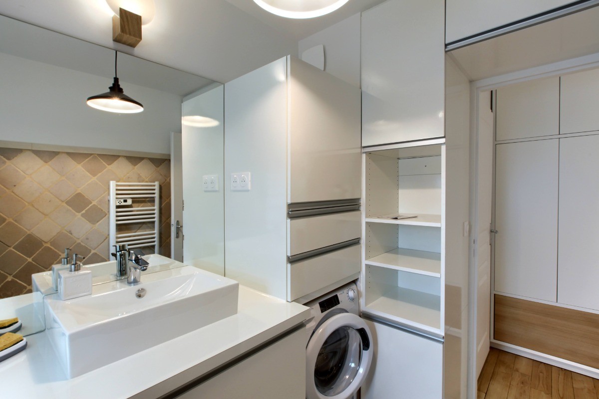 salle de bain équipée d'un lave linge, sèche cheveux, baignoire