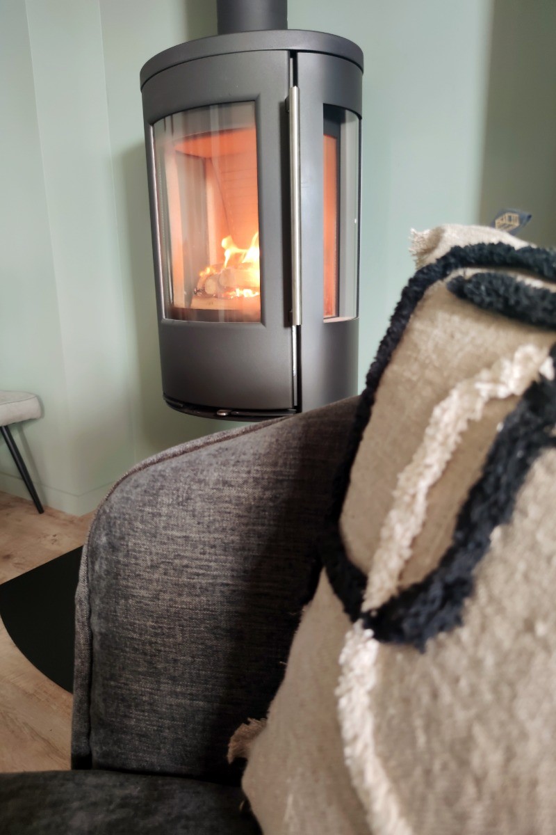Détail de l'appartement de plain pied : coin salon avec poêle à bois