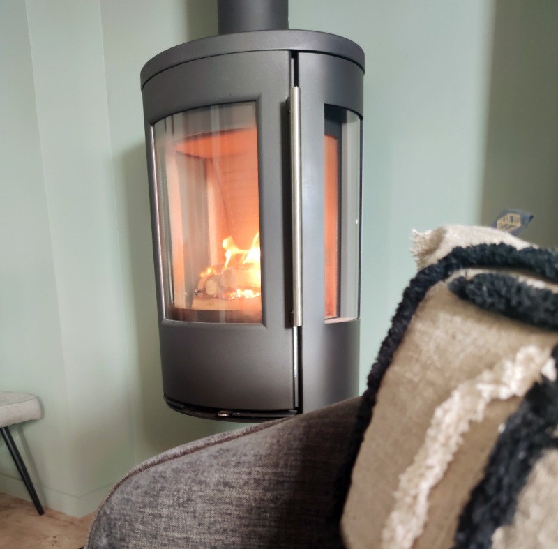 Détail de l'appartement de plain pied : coin salon avec poêle à bois