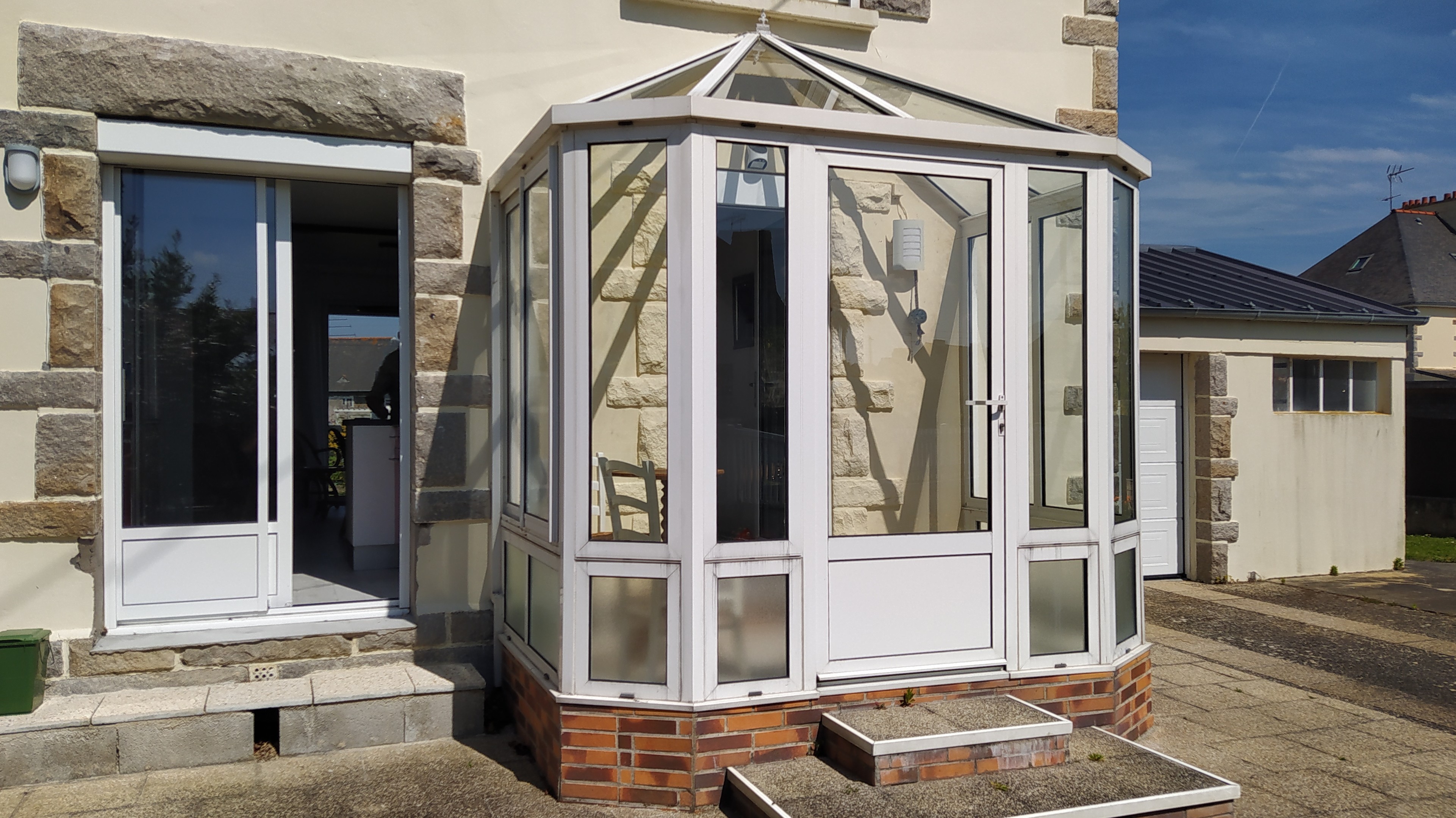 Façade avant de la maison avec cour, stationnement privatif extérieur devant le garage. Garage sécurisé pour stocker vos vélos, poussettes, paddle, etc.