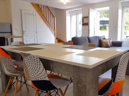 Grande pièce de vie de 32 m² avec coin cuisine toute équipée, coin séjour et coin salon. Accès à la terrasse de plain-pied.