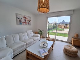 Salon avec vue sur terrain de pétanque et paillotte