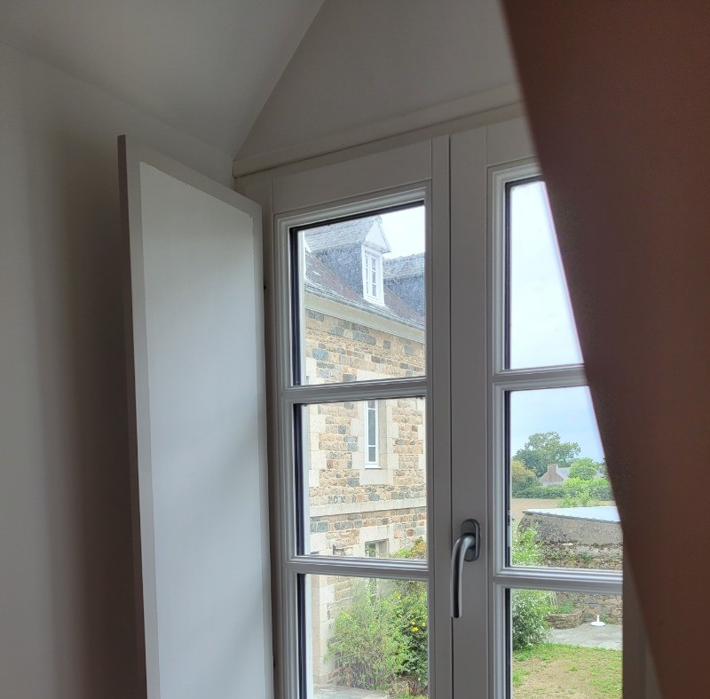 Chauvin, location, Clévacances, Paimpol, Plounez, chambre étage droite lit 160 avec bureau, vue de la fenêtre sur cour et église du bourg de Plounez