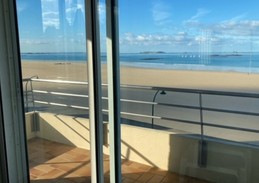 Depuis le balcon, vue imprenable sur la plage du Sillon et la cité fortifiée de Saint-Malo (intra-muros). Table et chaises d'extérieur installées à la belle saison.