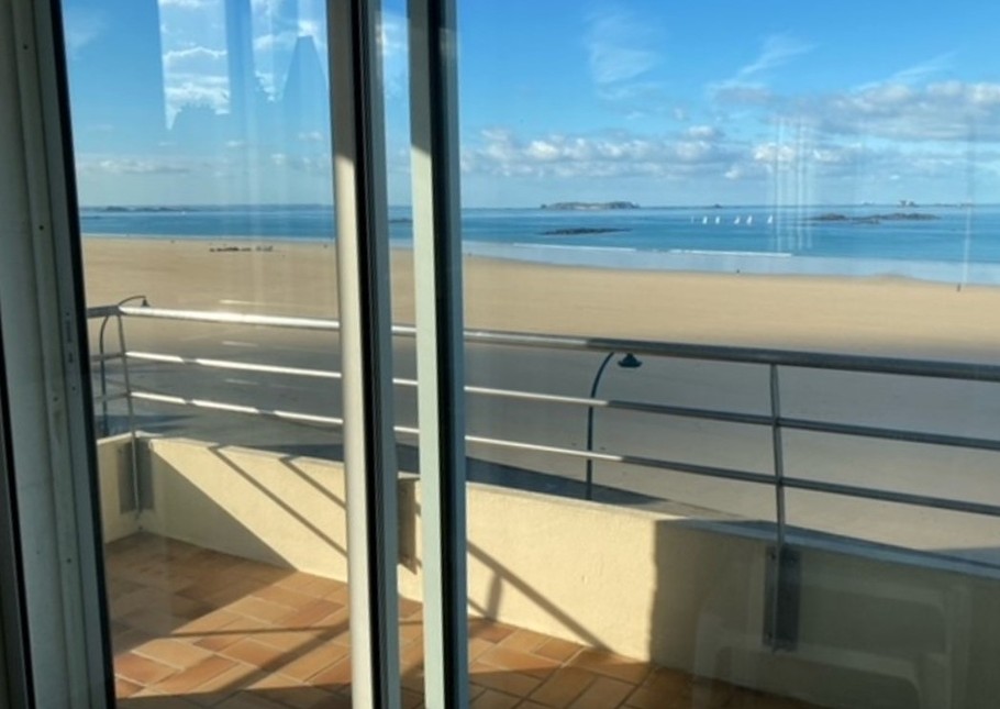 Depuis le balcon, vue imprenable sur la plage du Sillon et la cité fortifiée de Saint-Malo (intra-muros). Table et chaises d'extérieur installées à la belle saison.