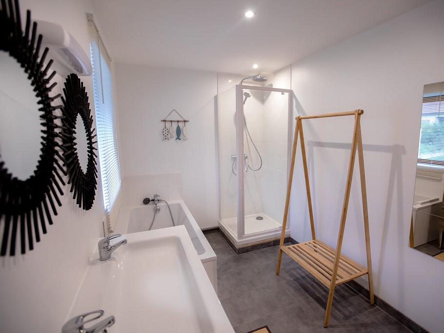 Salle de bains avec baignoire, douche et double vasques au RDC