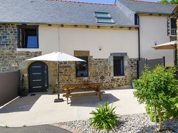 Façade du gîte avec sa terrasse. Autre gîte mitoyen à droite