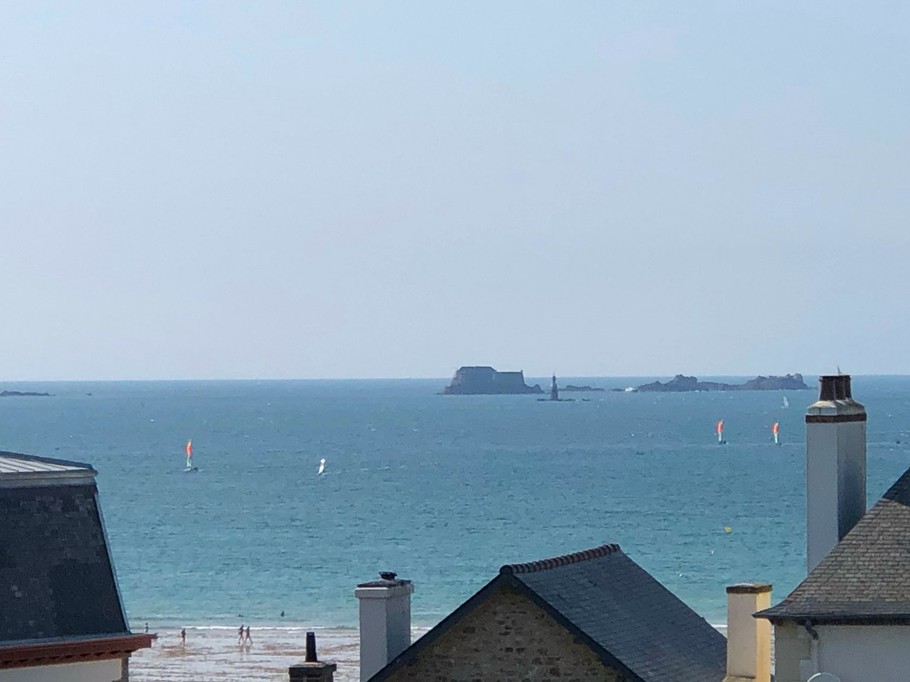 Vue magnifique depuis le balcon vers la plage du Sillon à Saint-Malo. Salon de jardin pour 2 personnes et 2 chaises relaxantes.