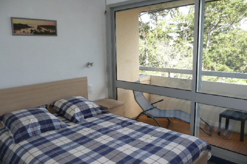Chambre avec lit 140 et armoire penderie donnant sur un balcon