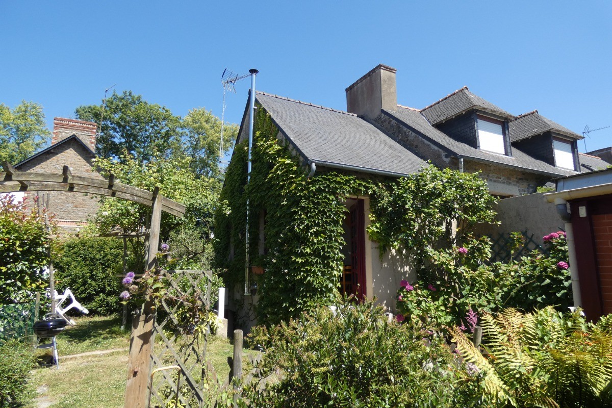 Façade de la maison fleurie au gré des saisons. Jardin privatif à votre disposition avec salon de jardin, transats, et barbecue.