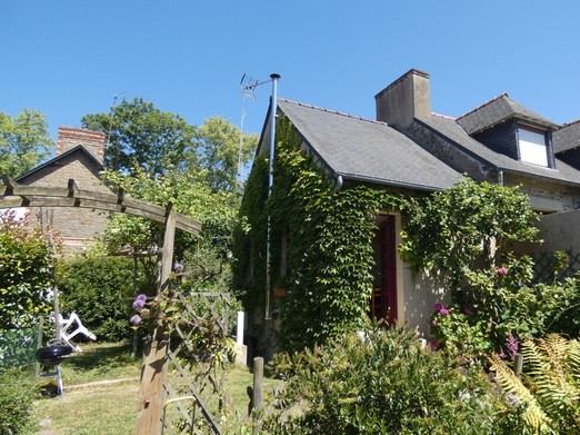 Façade de la maison fleurie au gré des saisons. Jardin privatif à votre disposition avec salon de jardin, transats, et barbecue.